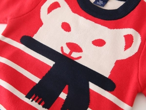 Close-up of red and white striped knit sweater with cute bear jacquard detail