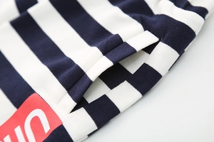 Detail shot of blue and white striped knit shorts with side pocket and red logo patch