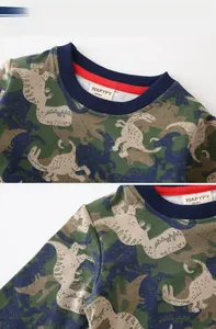 Detail of baby boys' autumn sweatshirt showing dinosaur pattern and ribbed neckline