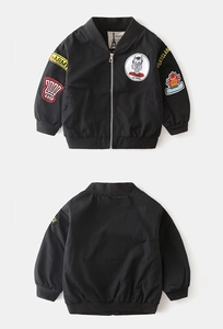 Detailed view of kids bomber jacket featuring vintage army patches and ribbed collar
