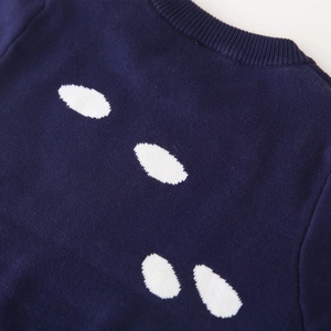 Detalle del suéter de punto azul marino con cuello redondo acanalado y motivos de nubes