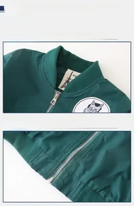 Detail of dark green bomber jacket showing ribbed collar, metal zipper, and cat patch