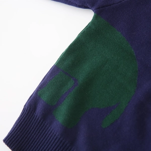 Detalle de jersey de punto azul marino con puño acanalado y diseño de elefante verde