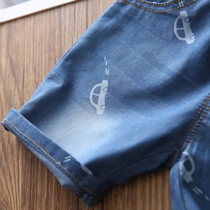 Pantaloncini jeans bimbo con stampa auto e orli risvoltati su base in legno