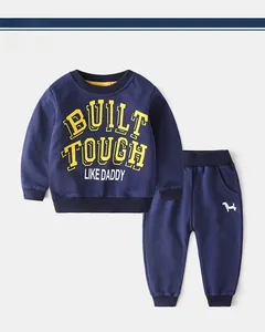 Detail of navy kids tracksuit set with yellow slogan and small puppy embroidery on pants