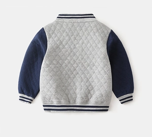 Dettaglio giacca baseball bambino con tessuto trapuntato a rombi grigi e maniche blu navy