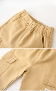 Detail of khaki cargo pants showing elastic waistband and side utility pocket stitching