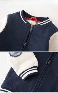 Detail of quilted navy boy's baseball jacket showing ribbed collar and metallic zipper