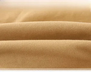 Macro detail of thick khaki cotton fabric showing twill texture of children's winter pants