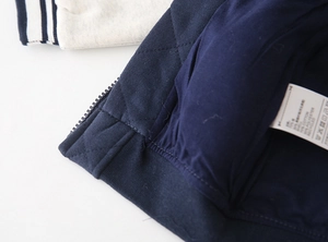 Close-up of diamond quilted fabric with ribbed cuffs and cotton lining on baseball jacket