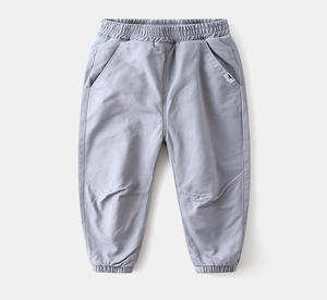 Detail of children's fleece pants with elastic waistband and dinosaur patch in grey