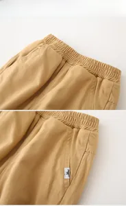 Detail of children's khaki fleece-lined pants showing elastic waist and kangaroo patch