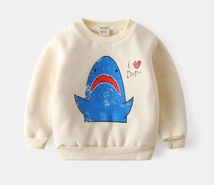 Close-up of cream sweatshirt featuring a cartoon shark print and ribbed cuffs