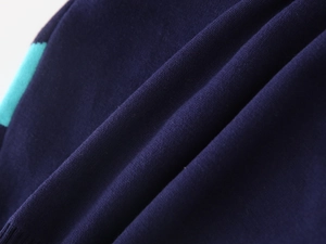 Detailed view of dark blue knit fabric with green striped accents and soft texture