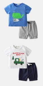 Detail view of cotton kids summer sets featuring whale and dump truck prints with shorts