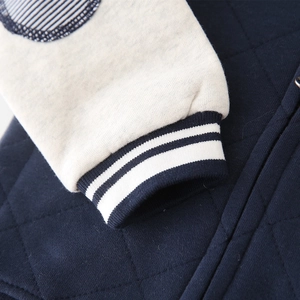 Boys navy blue quilted baseball jacket with grey sleeves and striped ribbed cuffs