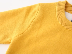 Detail of yellow knit sweater showing ribbed crew neck and fine fabric texture for boys