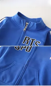 Detail view of boys blue sports jacket showing zipper collar and letter print