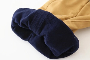 Détail de la doublure épaisse en polaire bleu marine à l'intérieur du pantalon brun pour enfant
