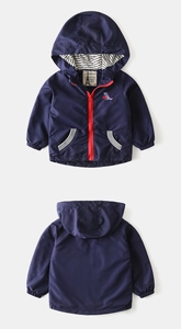 Detail of navy kids hoodie with red zipper and dinosaur embroidery on a flat lay view