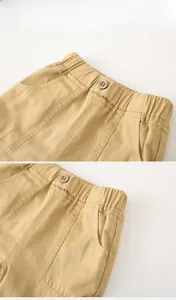 Detail view of khaki cotton shorts with elastic drawstring waist and vintage wooden button