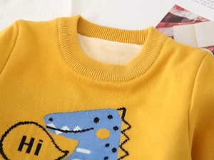 Detailed view of kids yellow knit sweater with warm fleece lining and dinosaur graphic