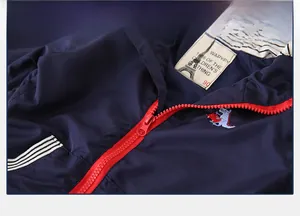 Close-up of a kids navy jacket featuring a red plastic zipper and dinosaur embroidery
