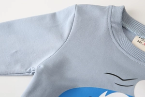 Detail of light blue kids sweatshirt featuring ribbed neckline and cartoon print embroidery