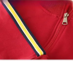 Detailed macro view of children's red cotton sweatshirt with metal zipper and striped ribbon