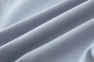 Macro shot of soft light blue knitted fabric texture for children's casual sweatshirt