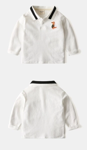 Détail d'un polo enfant en maille gaufrée blanche avec broderie dinosaure orange