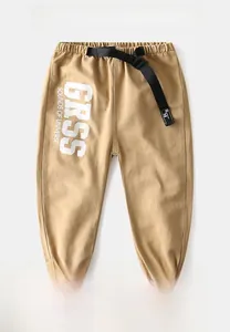 Detail of khaki jogger pants with black buckle belt and white GRSS graphic print
