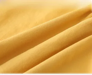 Detailed close-up of yellow twill fabric texture on children's long sleeve shirt