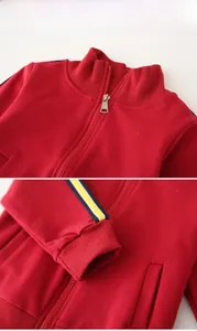 Detail of red kids zip-up jacket with stand collar and tricolor sleeve stripes