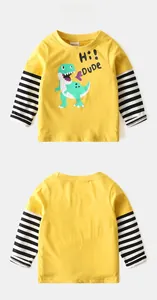 Detail view of yellow long-sleeve kids shirt with cartoon dinosaur and stripe sleeves