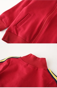 Detail of red kids zip jacket with shoulder stripes and smooth premium stitching