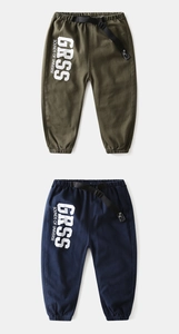 Detail of kids cargo pants featuring elastic waist with buckle and bold letter print