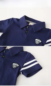 Detail eines dunkelblauen Polo-Shirts mit Kragenknöpfen und gestreiften Rippbündchen
