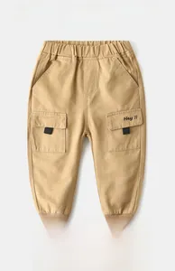 Detail of light khaki kids cargo pants featuring elastic cuffs and 'Hey !!' embroidery