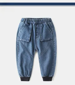 Detail of kids blue jeans featuring elastic waistband and large geometric cargo pockets