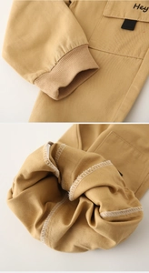 Detailed close-up of khaki cotton joggers featuring embroidered Hey logo and ribbed cuffs