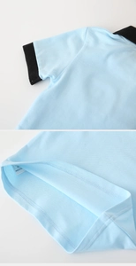 Detail of boys' light blue polo shirt showing ribbed cuffs, collar, and stitching hem