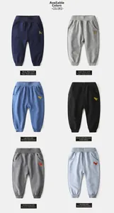 Flat lay of kids joggers featuring tiger and dinosaur embroidery in six different colors