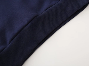Macro view of navy blue thick hoodie showing high-quality ribbed cuffs and cotton fabric texture