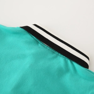 Macro shot of green boys polo shirt collar with detailed black and white stripe ribbing