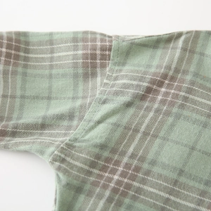 Macro shot of green and grey plaid shirt shoulder seam with high quality twill fabric texture