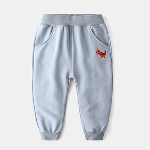 Close-up of children's grey-blue joggers with red dinosaur embroidery and ribbed cuffs