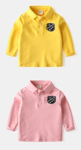 Dettaglio di polo in cotone per bambini giallo e rosa con stemma ricamato sul petto