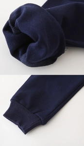 Detail of dark blue joggers showing knitted fabric texture and elastic ribbed cuff