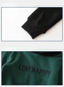 Detail of boys' hoodie showing green fabric with LOVEWAPYPY embroidery and black ribbed cuffs